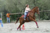 Une jolie cavali�re exterieure sur son grand cheval alezan font l'�preuve de pole bending.